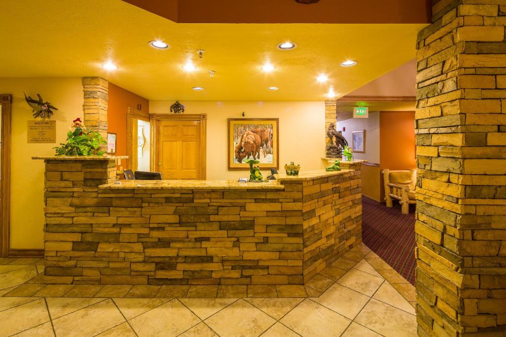 a bar in a lobby with a brick wall at Alpine Inn & Suites Gunnison in Gunnison