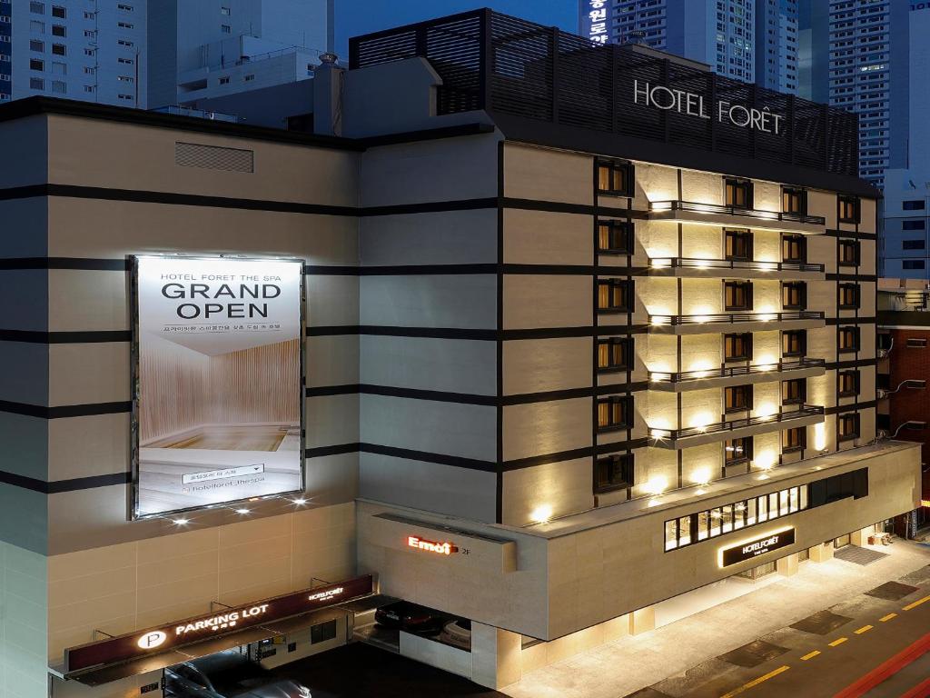 a hotel with a sign on the side of a building at Hotel Foret The Spa in Busan