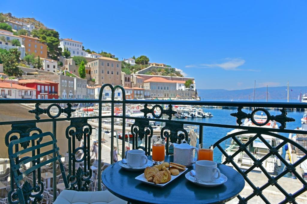 une table bleue avec de la nourriture au-dessus d'un balcon dans l'établissement Hotel Sophia, à Hydra