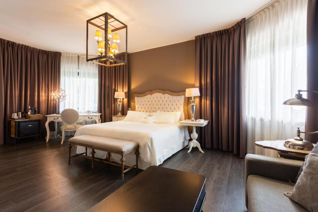 ein Schlafzimmer mit einem großen Bett und ein Wohnzimmer in der Unterkunft Like Home Boutique Hotel in Azzano San Paolo