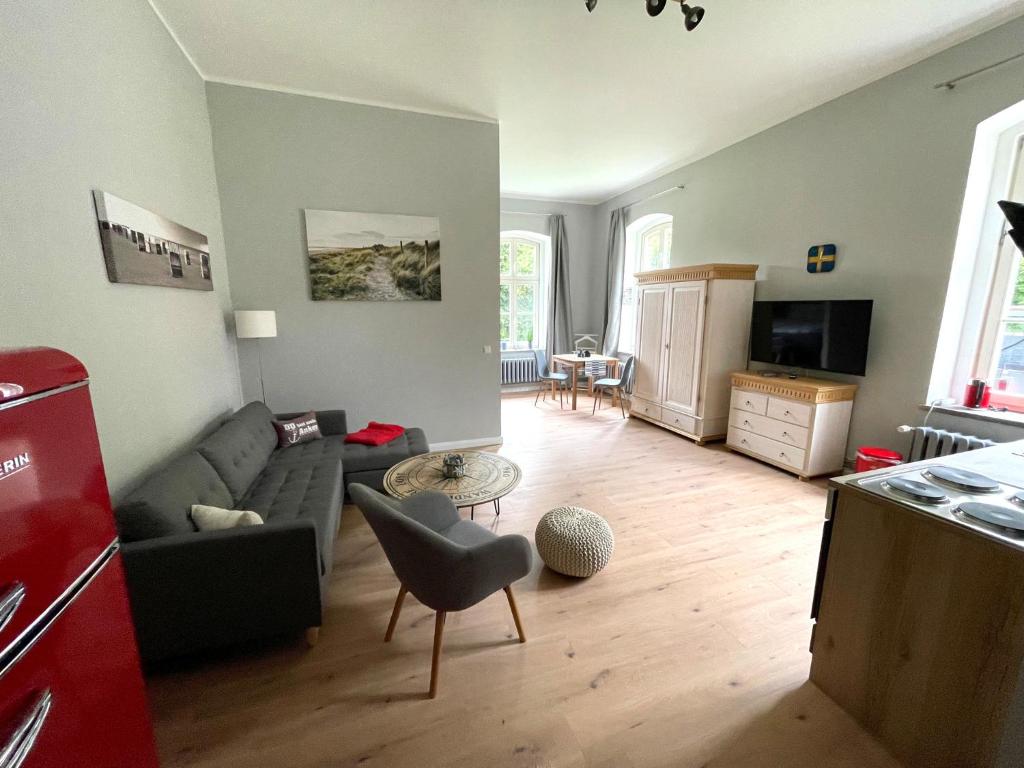 uma sala de estar com um sofá e uma mesa em Gästehaus Sternschanze - App2 Kapitänleutnant em Stralsund