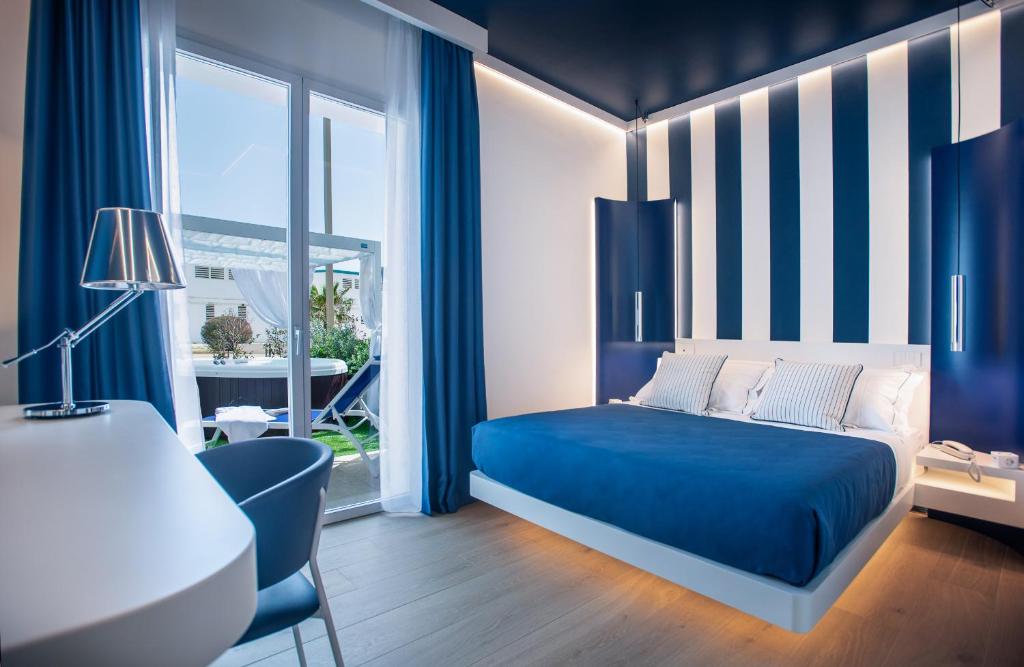 um quarto azul e branco com uma cama e uma secretária em Hotel Nautilus em Cagliari