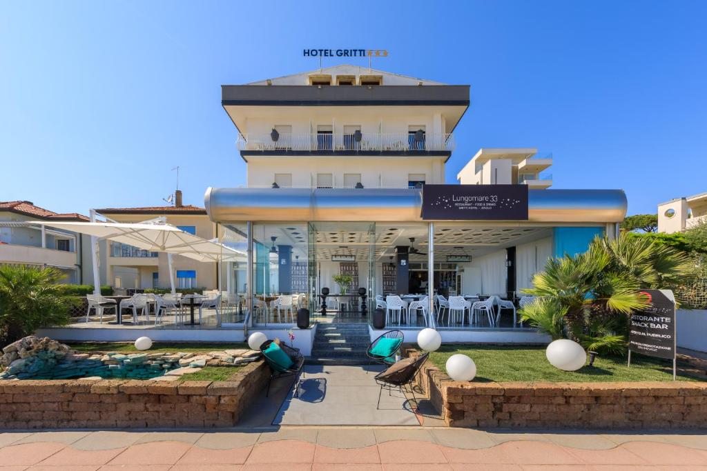 a hotel building with a fountain in front of it at Hotel Gritti in Lido di Jesolo