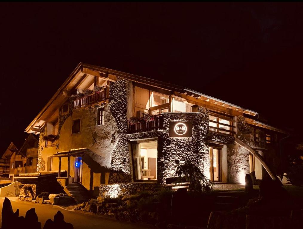 a large stone building with a sign on it at night at AL BAIT DA LUCIA Bormio in Bormio