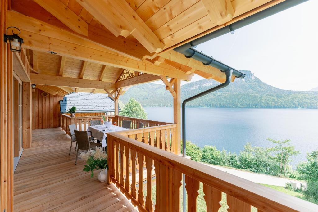 een houten terras met uitzicht op een meer bij Villa Frischmuth am See in Altaussee