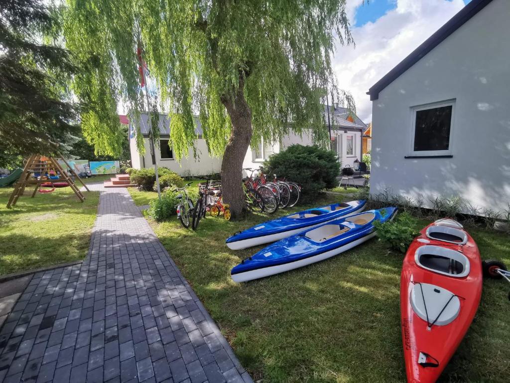 eine Gruppe Kajaks auf dem Rasen neben einem Haus in der Unterkunft DOMKI KAJUTA in Żarnowska