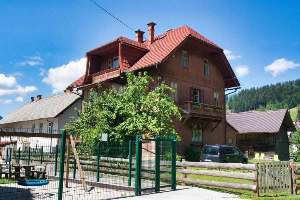 ein Haus mit einem Spielplatz davor in der Unterkunft Apartma Vila Kočna in Zgornje Jezersko