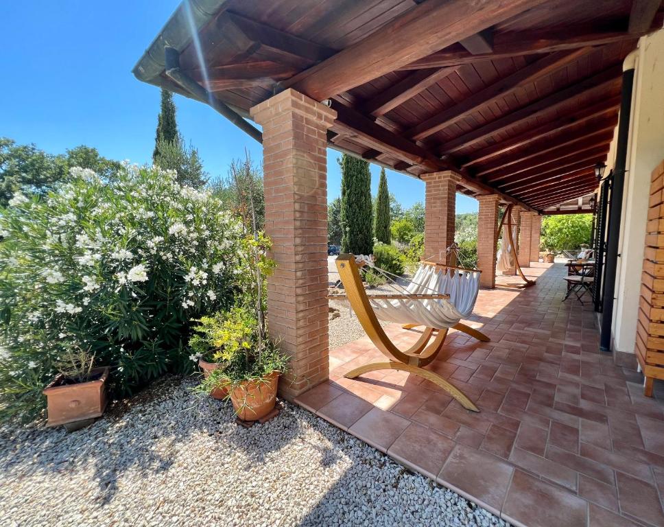 un patio con un banco y algunas plantas en Casale Terre Rosse, en Saturnia