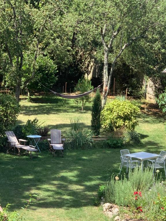 a yard with chairs and a hammock in the grass at L'adresse à Besançon in Besançon