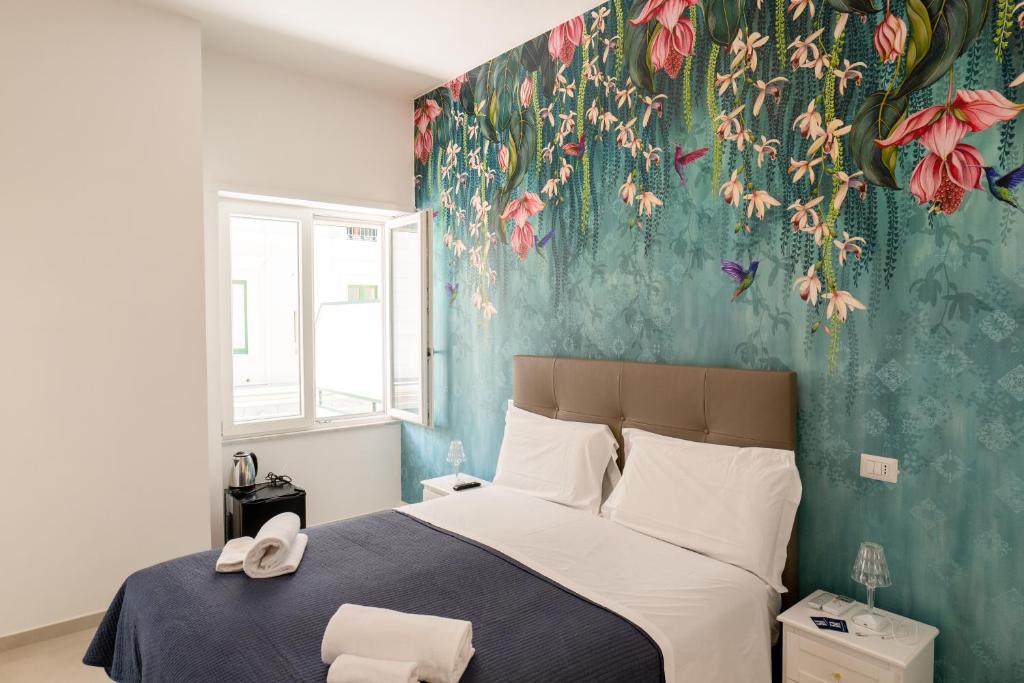 um quarto com uma cama com papel de parede floral em Relais Vittorio Veneto - Luxotel & Apartotel em Salerno