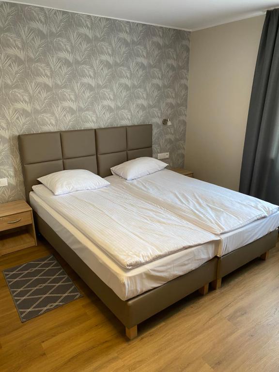 1 dormitorio con 1 cama grande con sábanas blancas en GRACJA, en Warszawa