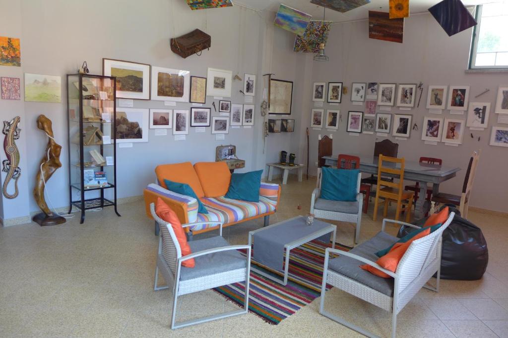 une chambre avec des chaises, une table et des photos sur le mur dans l'établissement Casa Mariolas, à Manteigas