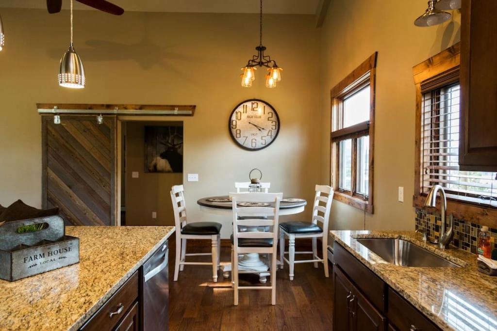 een keuken met een tafel en een klok aan de muur bij Spacious 2nd story loft with awesome views in Estes Park