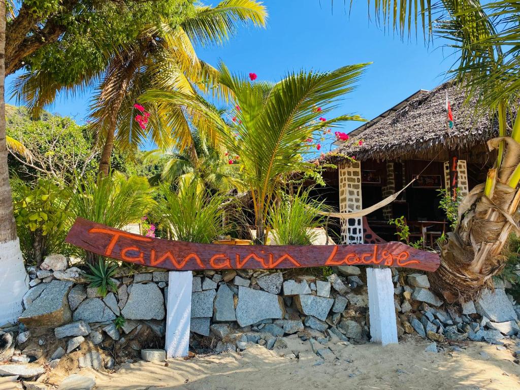 ein Schild am Strand vor einem Resort in der Unterkunft Tamarin Lodge in Ampangorinana