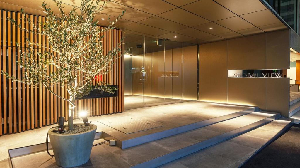 een lobby met een boom in een grote pot bij Hotel Global View Koriyama in Koriyama