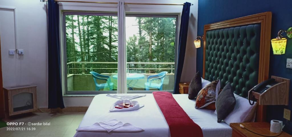 a bedroom with a bed and a window with a chair at Hotel Al Azeem in Ayubia