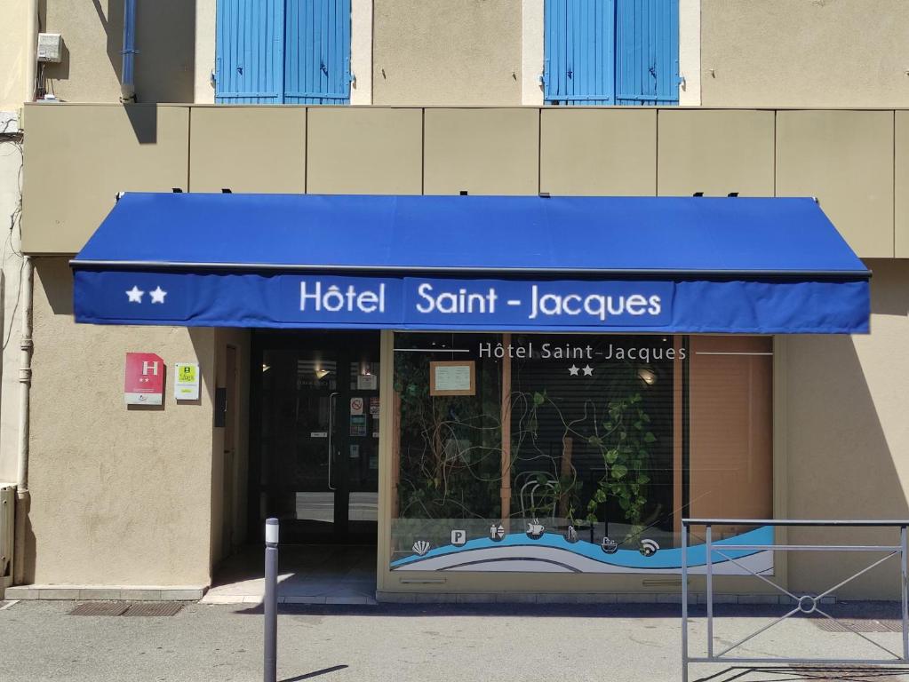 un negozio con un tendone blu di fronte a un edificio di Logis Hôtel Saint Jacques a Valence