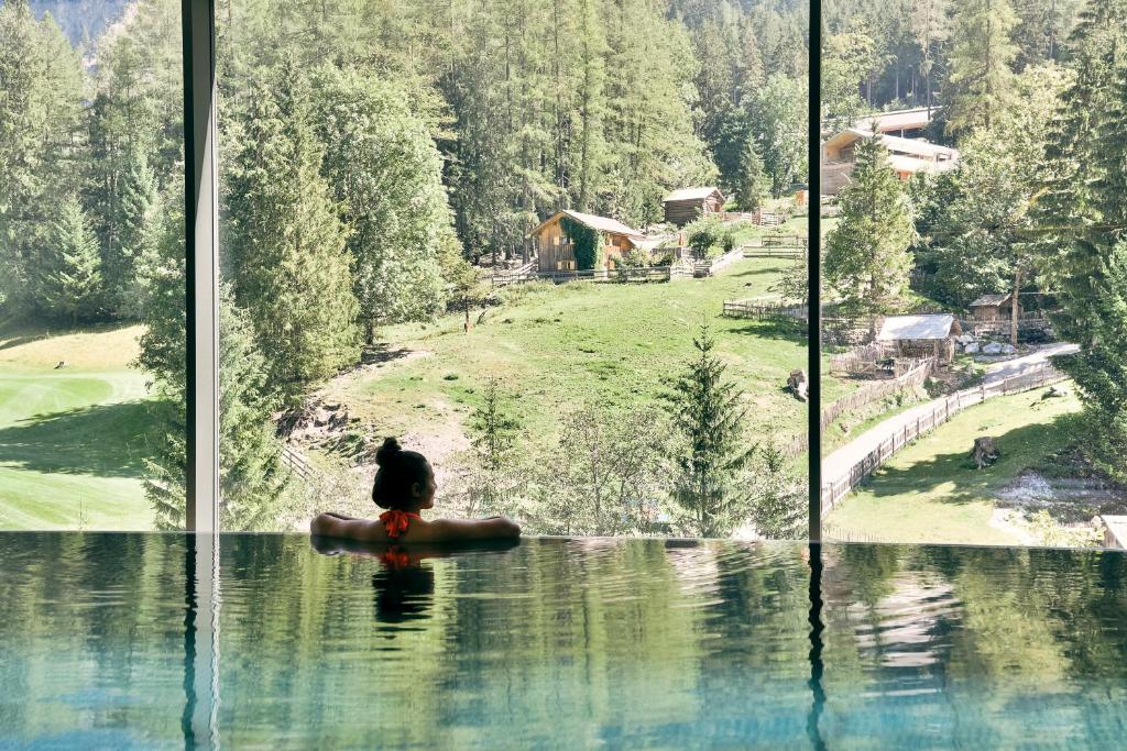 um pássaro preto sentado numa pedra numa janela de vidro em Aktiv-Hotel Sarotla em Brand