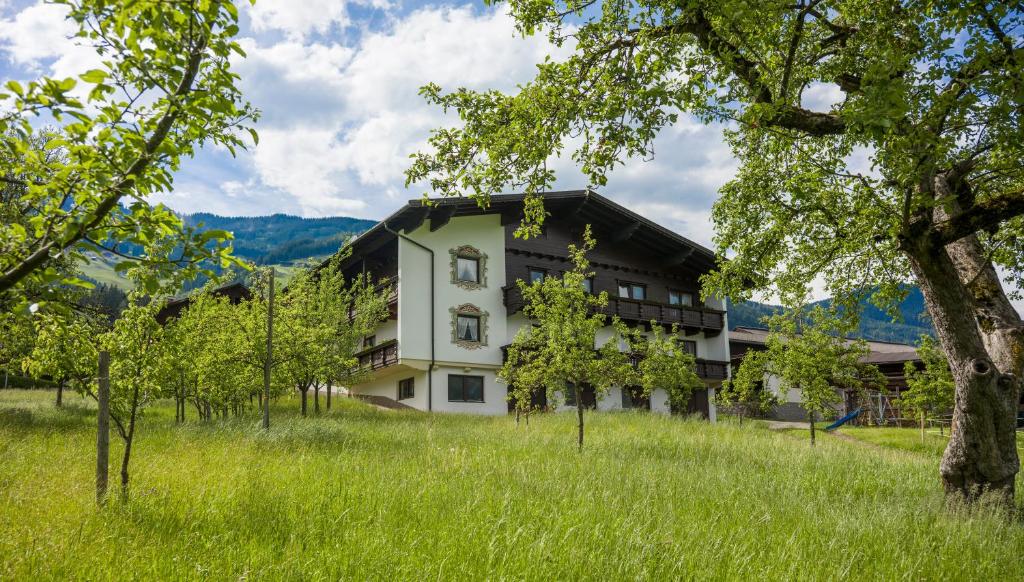 um edifício branco num campo com árvores em Riemenerhof em Fügen