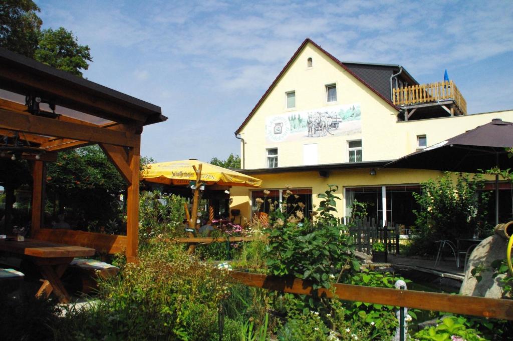 a building with a garden in front of it at Landhotel Heidekrug in Dohma