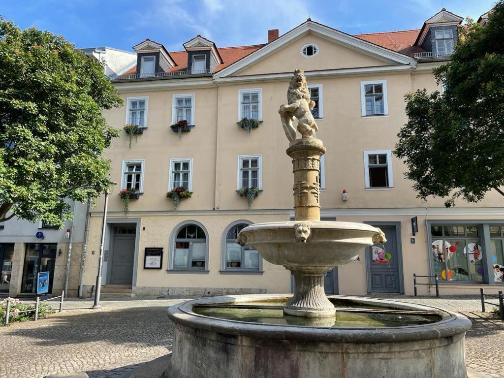 uma fonte num pátio em frente a um edifício em Pension Altstadt em Veimar