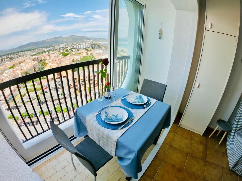 einen blauen Tisch und Stühle in einem Zimmer mit Balkon in der Unterkunft Bay View Empuriabrava in Empuriabrava