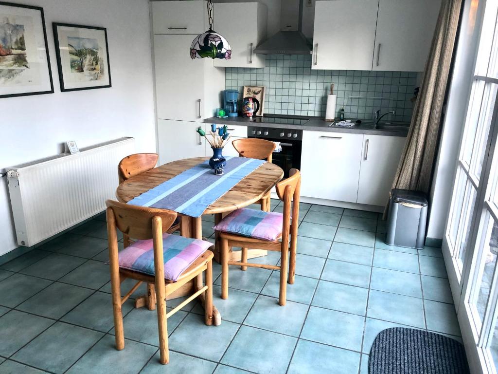 - une cuisine avec une table et des chaises en bois dans l'établissement Strandbummelhaus, à Warnemünde