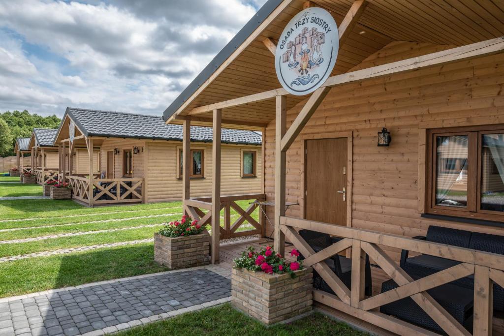 eine Hütte mit einem Schild an der Seite in der Unterkunft Osada Trzy Siostry in Pobierowo