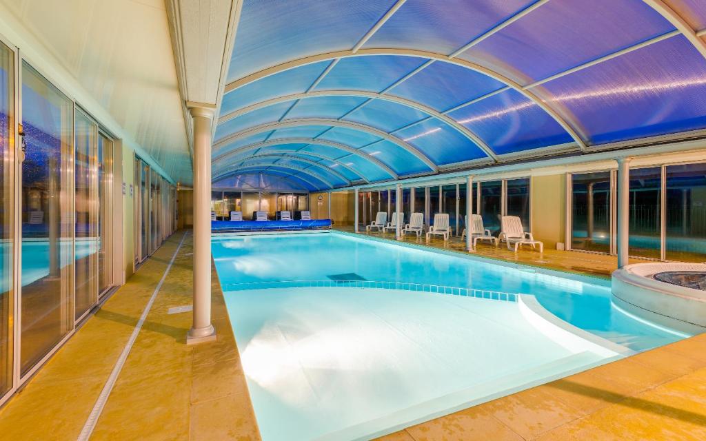 a large swimming pool with a domed ceiling at Lagrange Vacances Le Hameau De Peemor Pen in Crozon