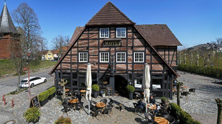 um edifício com um carro estacionado em frente em Meyers Hotel Hittfeld em Seevetal