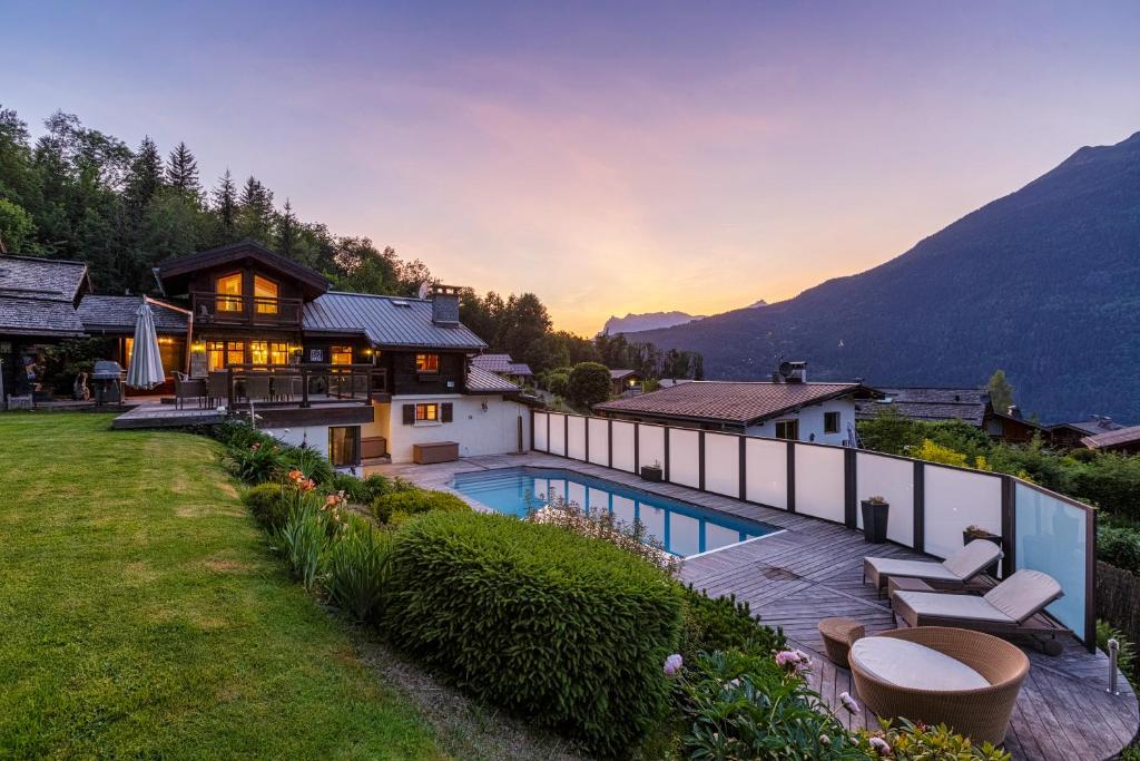 ein Haus mit einem Pool und einem Berg in der Unterkunft Chalet Galadhrim Chamonix Mont Blanc Valley in Les Houches