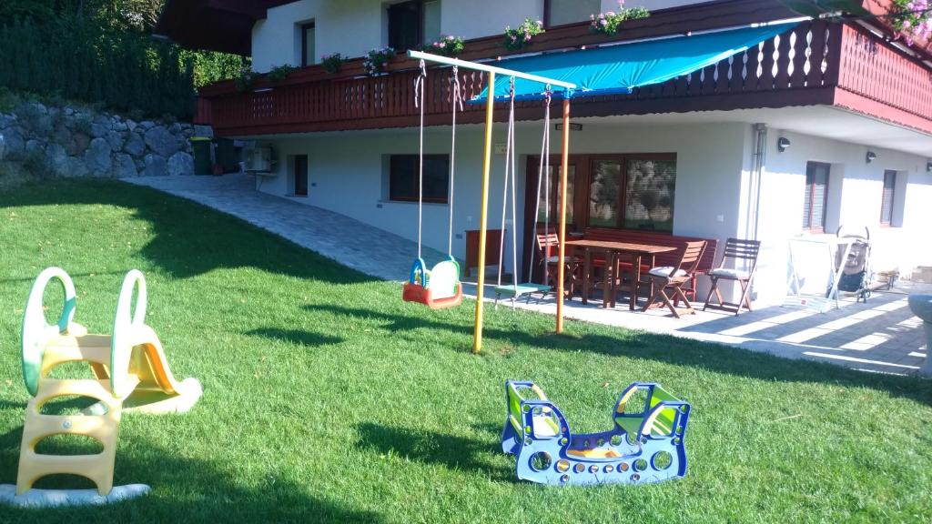 einen Hof mit Spielgeräten vor einem Haus in der Unterkunft Apartma Lara in Bled