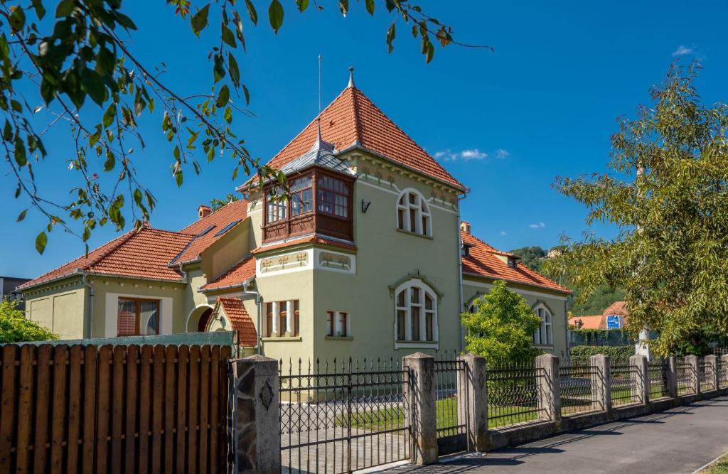 een oud huis met een hek ervoor bij Clasic Haus Sighisoara in Sighişoara