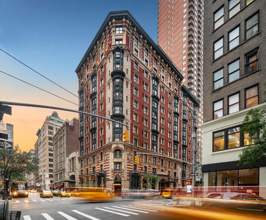 un edificio alto en una calle de la ciudad con tráfico en The James New York - NoMad, en Nueva York