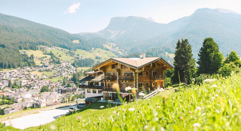 una casa de madera en la cima de una colina en Hotel Pradell, en Ortisei