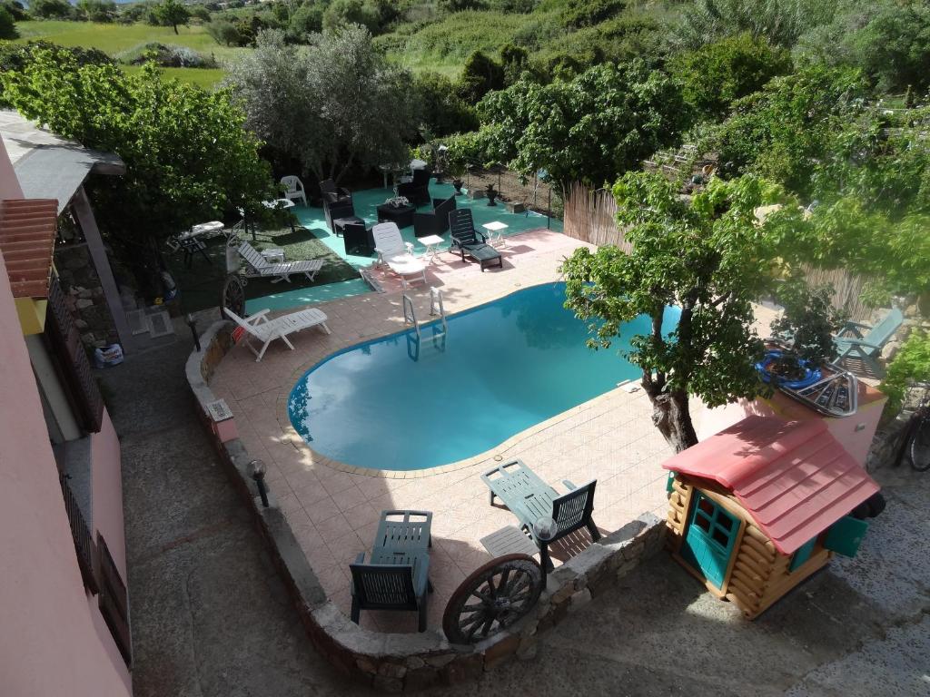 una vista sul soffitto di una piscina con sedie e tavoli di Casa Li Multi a Budoni