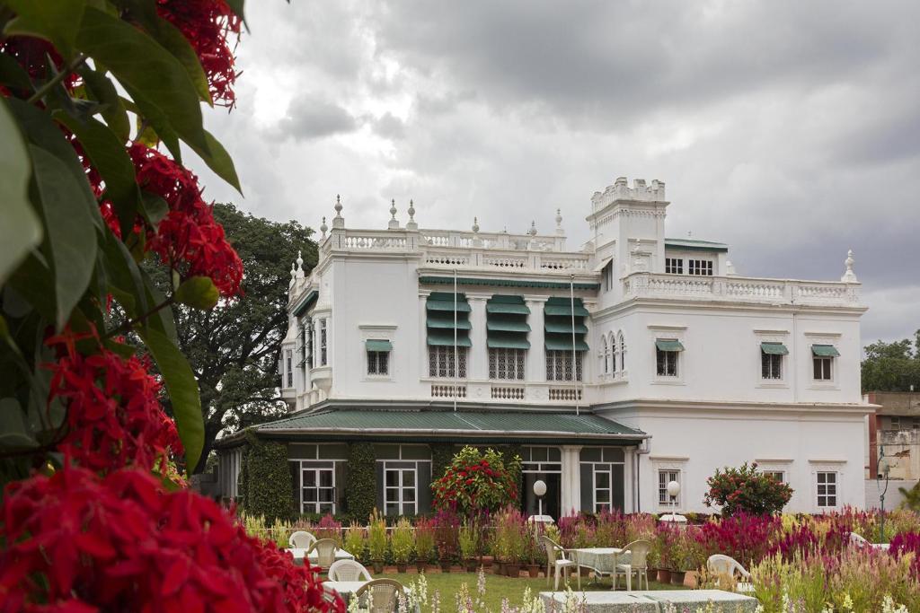 un edificio bianco con dei fiori davanti di The Green Hotel a Mysore