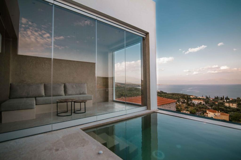 Mani Luxury Suites and Studios in Gytheio with Private Pools في غيتيو: منزل به مسبح ونافذة كبيرة