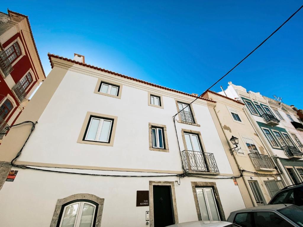 a tall white building with a black door at Baixa-Mar Setúbal Miradouro in Setúbal