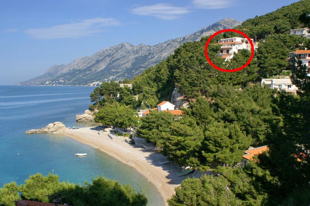 une maison au sommet d'une colline à côté d'une plage dans l'établissement Apartments by the sea Brela, Makarska - 6688, à Brela