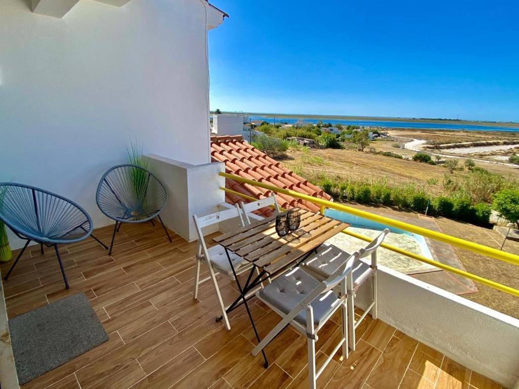 d'un balcon avec une table et des chaises et une vue sur l'océan. dans l'établissement Apartamento Aldeia de Marim, Ohao, Portugal, Meerblick, à Olhão