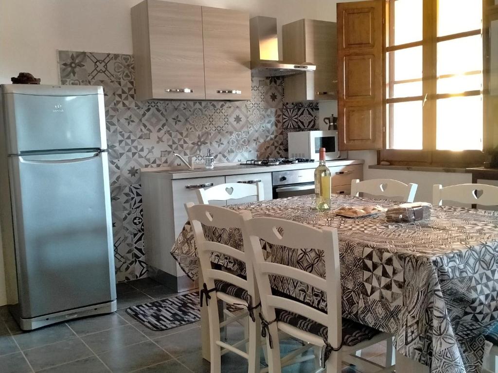 a kitchen with a table with chairs and a refrigerator at Casa Margherita in Càbras