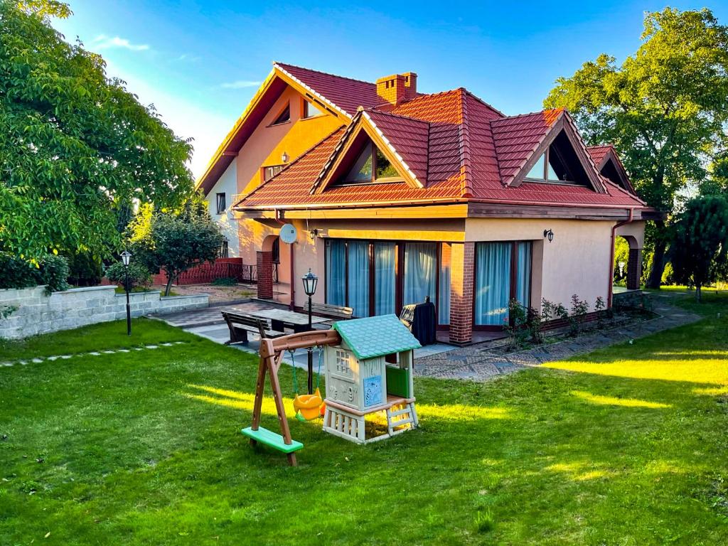 une maison avec une aire de jeux dans la cour dans l'établissement Dom na Poniatowie, à Wałbrzych