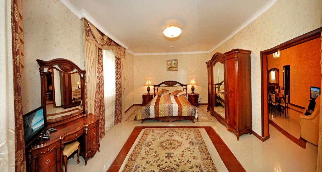 a bedroom with a bed and a dresser and a television at Гранд Алексік in Truskavets