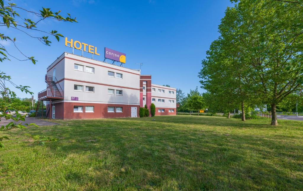 un bâtiment avec un panneau d'hôtel en haut dans l'établissement Hôtel Cerise Auxerre, à Monéteau