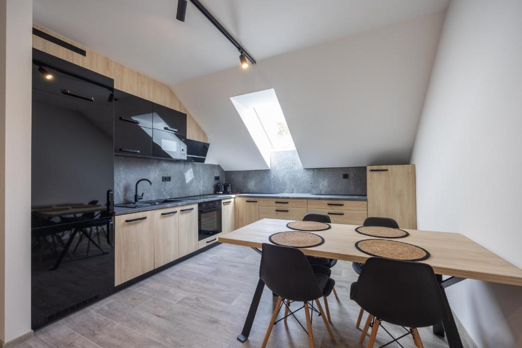 - une cuisine avec une table et des chaises en bois dans l'établissement Apartmány Na Lánech, à Litomyšl