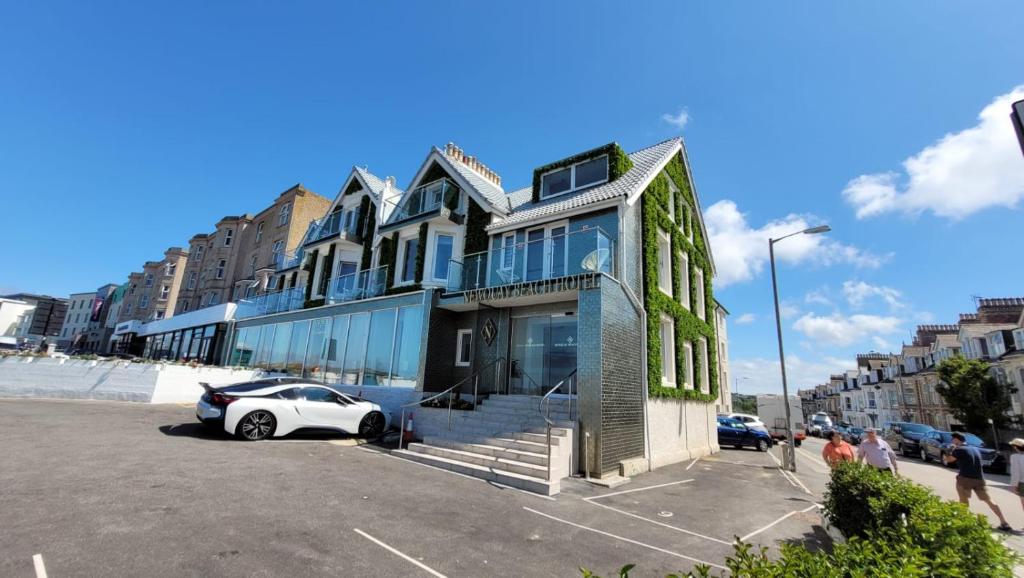 een gebouw met een auto geparkeerd op een parkeerplaats bij OYO Newquay Beach Hotel in Newquay