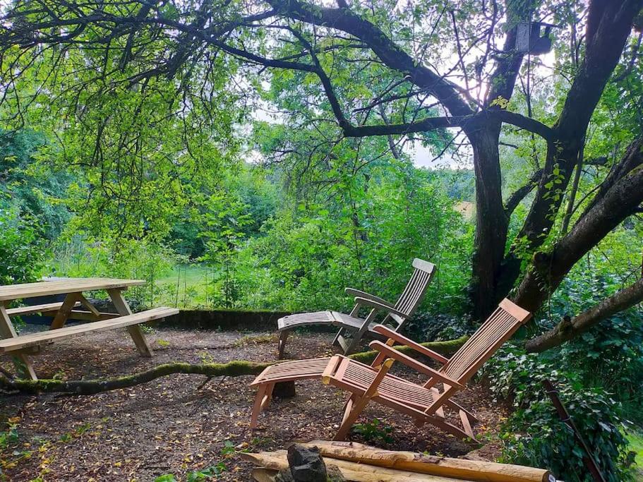 2 chaises en bois et une table de pique-nique sous un arbre dans l'établissement Tiny Messancy, une immersion dans la nature !, à Messancy