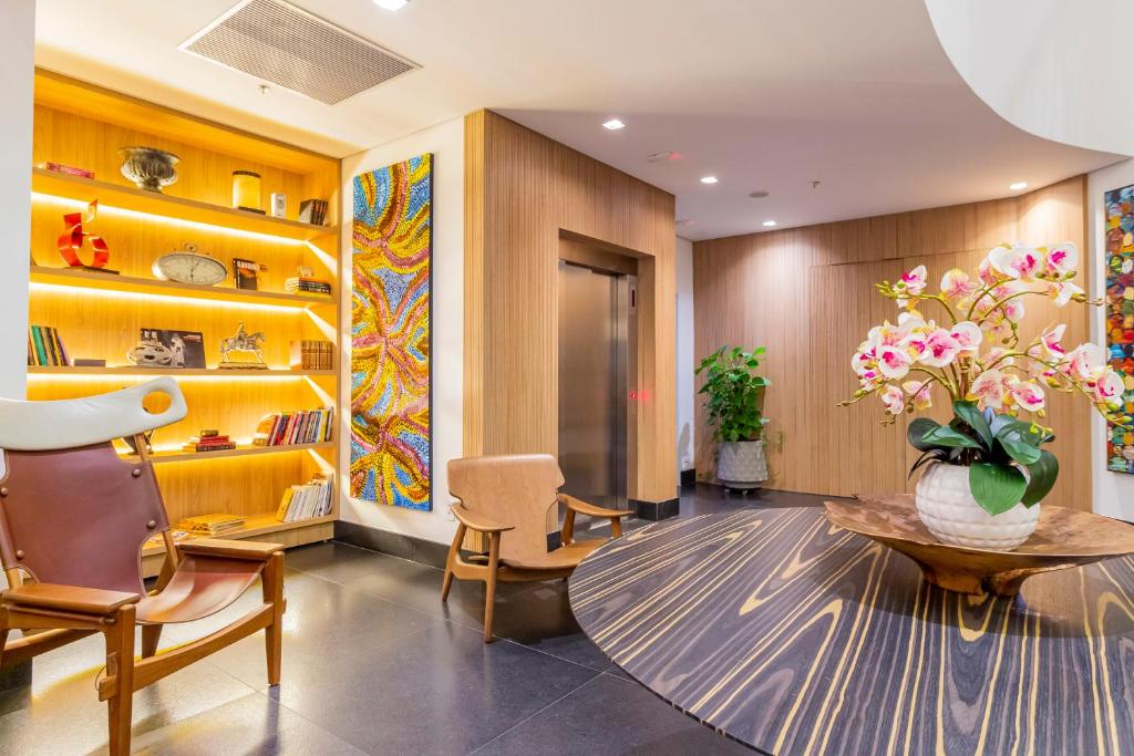 a lobby with a table and chairs and a vase of flowers at Hotel Cassino Tower São José do Rio Preto by Nacional Inn in Sao Jose do Rio Preto