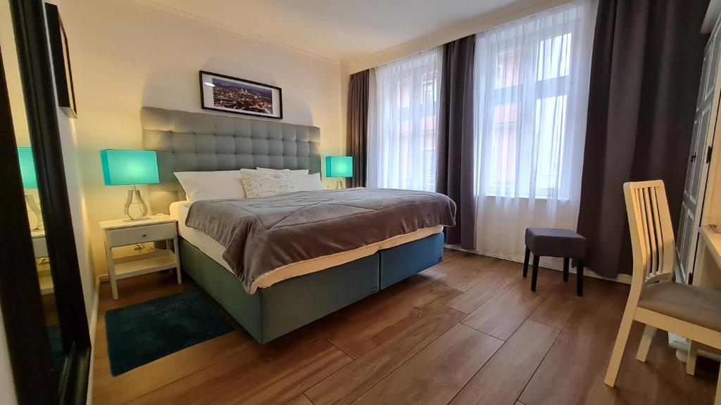 um quarto com uma cama, 2 janelas e uma cadeira em Hotel Domizil em Erfurt